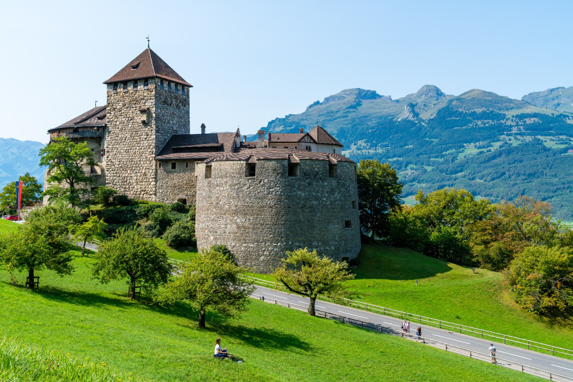 Zamek Vaduz na zielonym zboczu na tle gór w Liechtensteinie